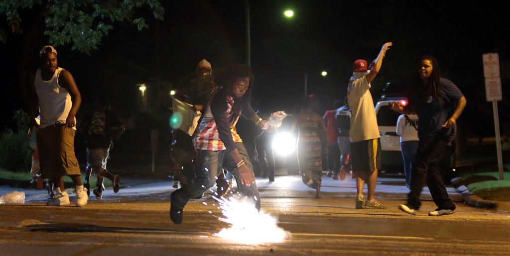 A tear gas canister lands at the feet of Edward Crawford.