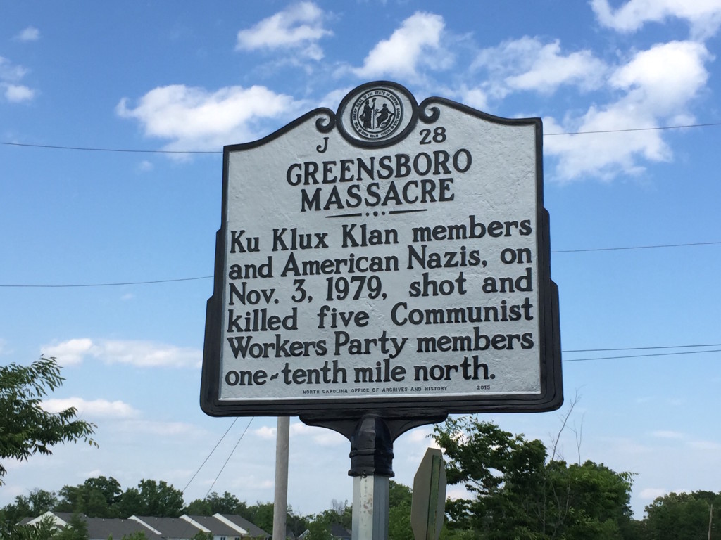 A memorial plaque for the Greensboro Massacre, reading: Ku Klux Klan members and American Nazis, on Nov. 3, 1979, shot and killed five Communist Workers Party members one-tenth mile north.