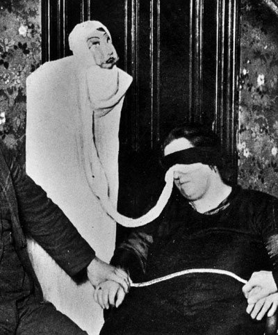 Helen Duncan, blindfolded, performing a seance.
